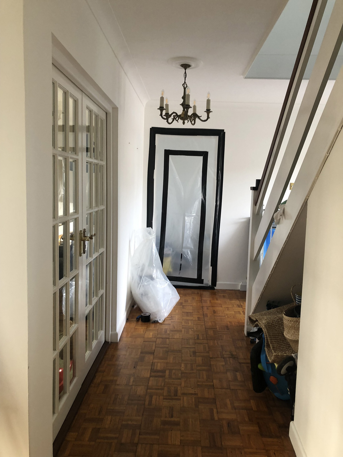 Initial plastic sheeting over office door with Y-cut entry point secured with black tape