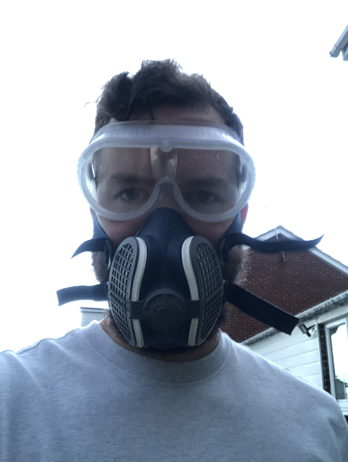 Person wearing safety goggles and FFP3 mask during asbestos salvage operation