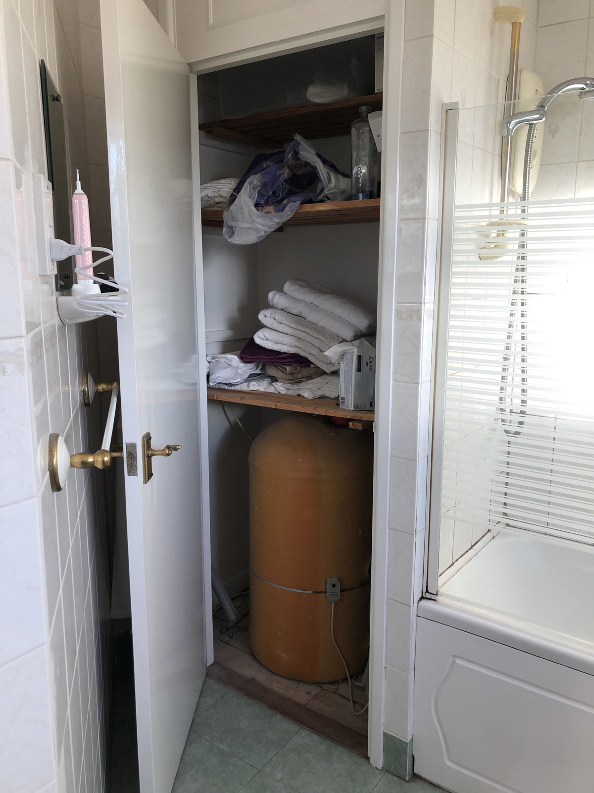 Airing cupboard before work started - showing old hot water cylinder that would be removed for combi conversion
