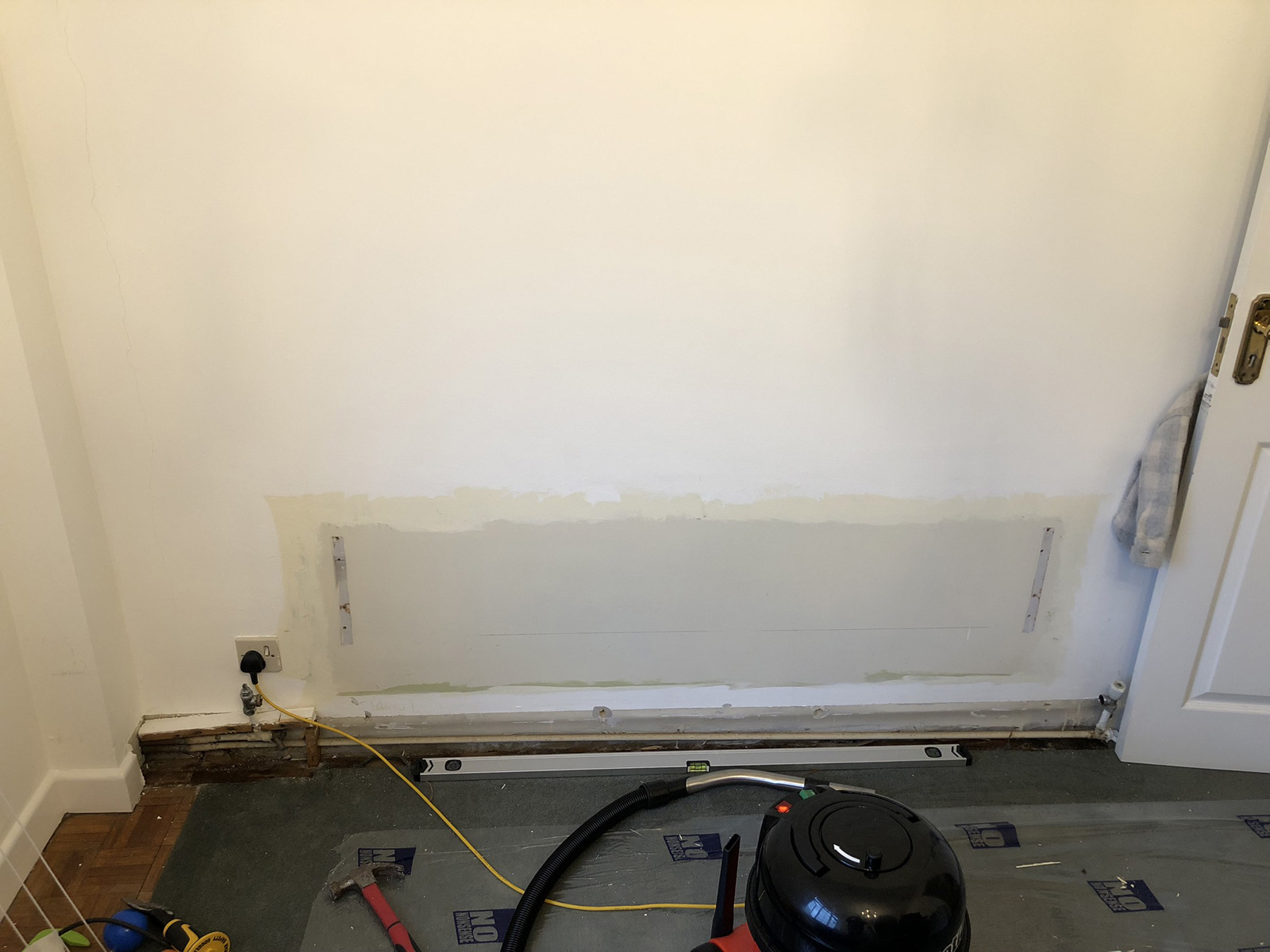 Old radiator removed showing wall before new installation