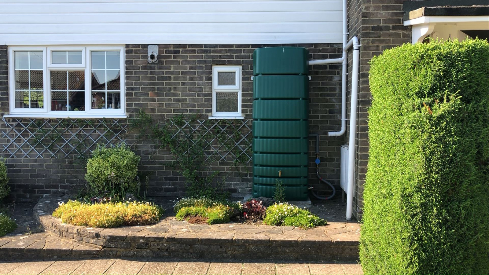 Completed rainwater harvesting system showing waterbutt installation