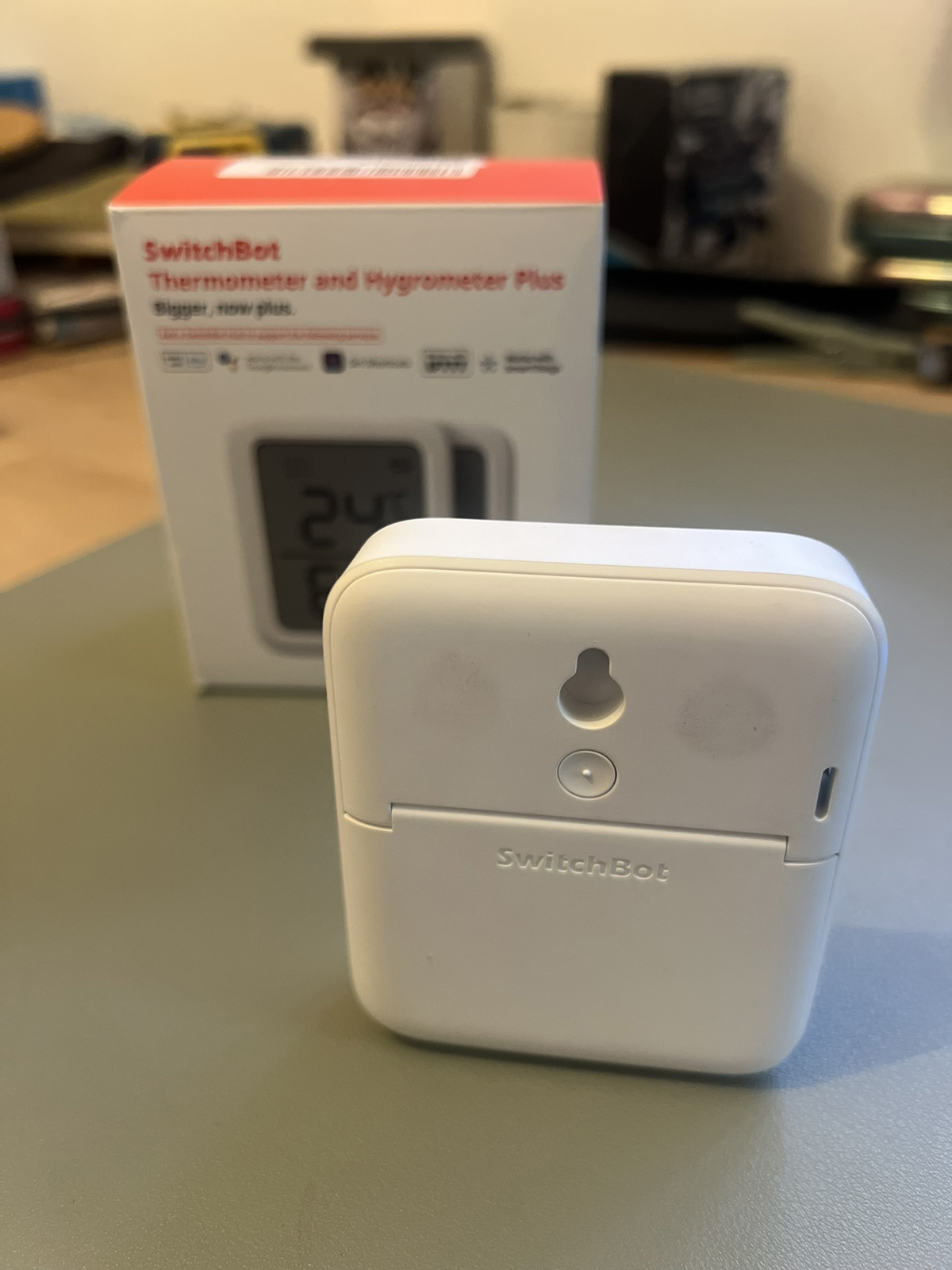 SwitchBot Meter Plus showing screw hole mount and upright standing position